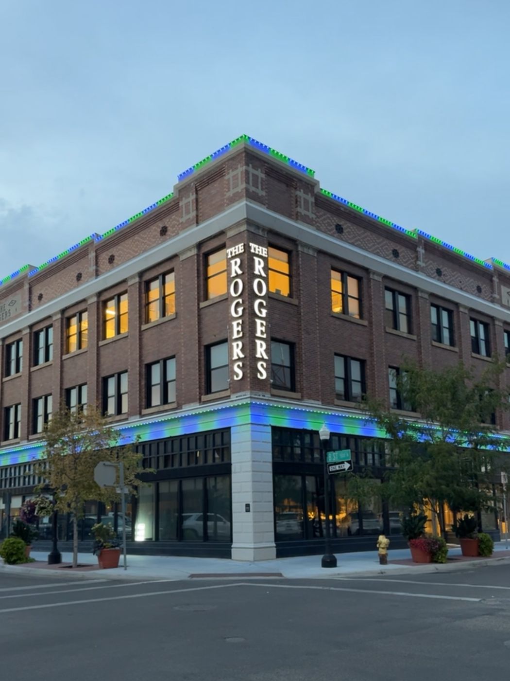The Rogers building with green and blue permanent lighting on the cornice and storefront band