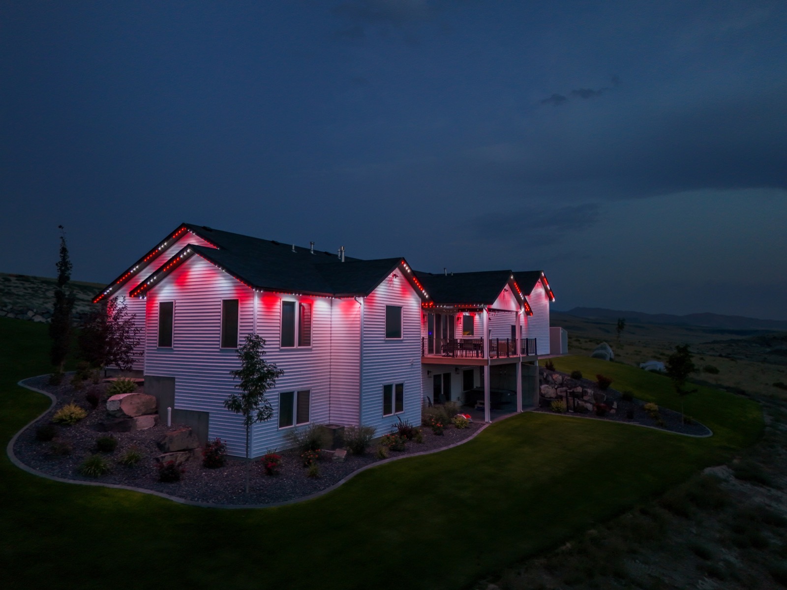 Drone view of a home glowing red and white for the holidays