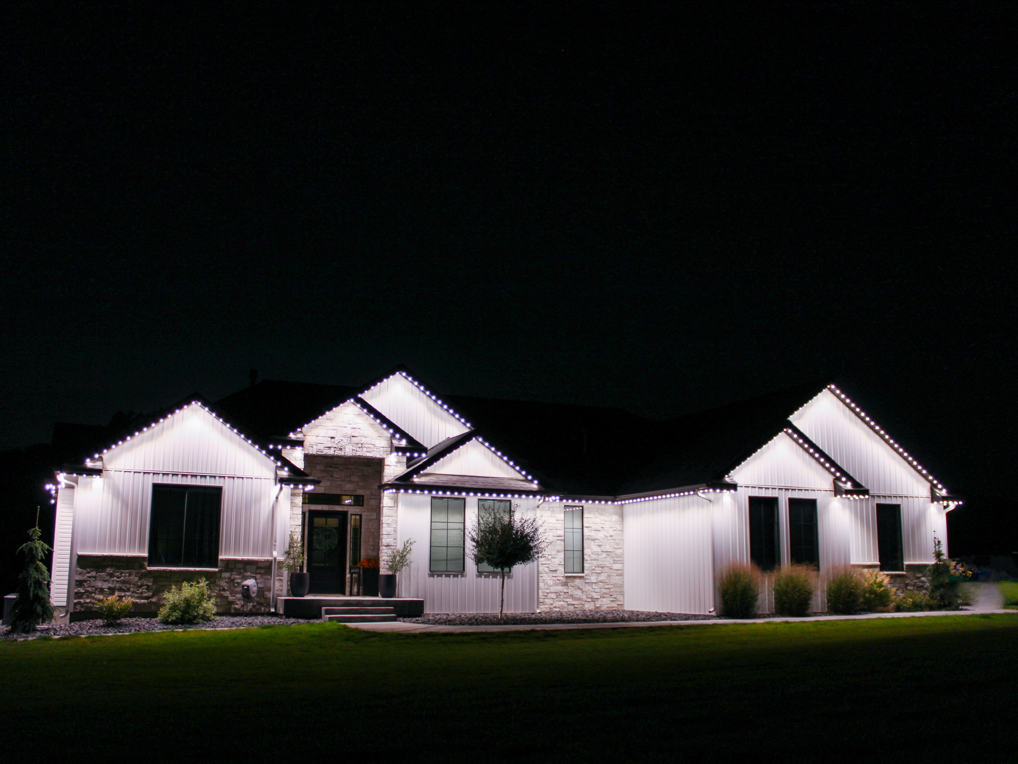 Home glowing crisp white against a black night sky, every approach lit